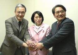 堅く握手する田村さん、緒方さん、笠井さん