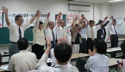 区議候補らとともに手を上げてこたえる笠井議員